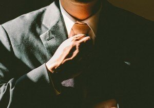 man straightening tie